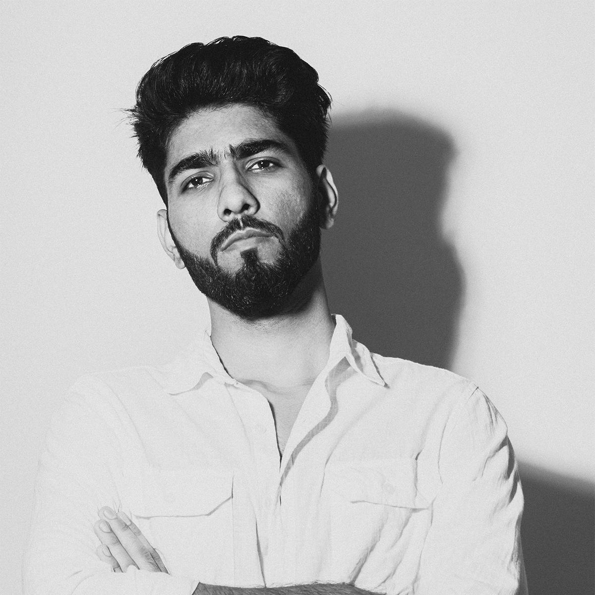 Ravinder Kumar in a light shirt, arms crossed